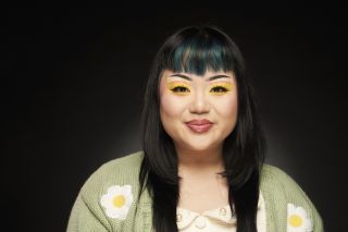 On-May against a black background with a bold yellow eyeshadow look