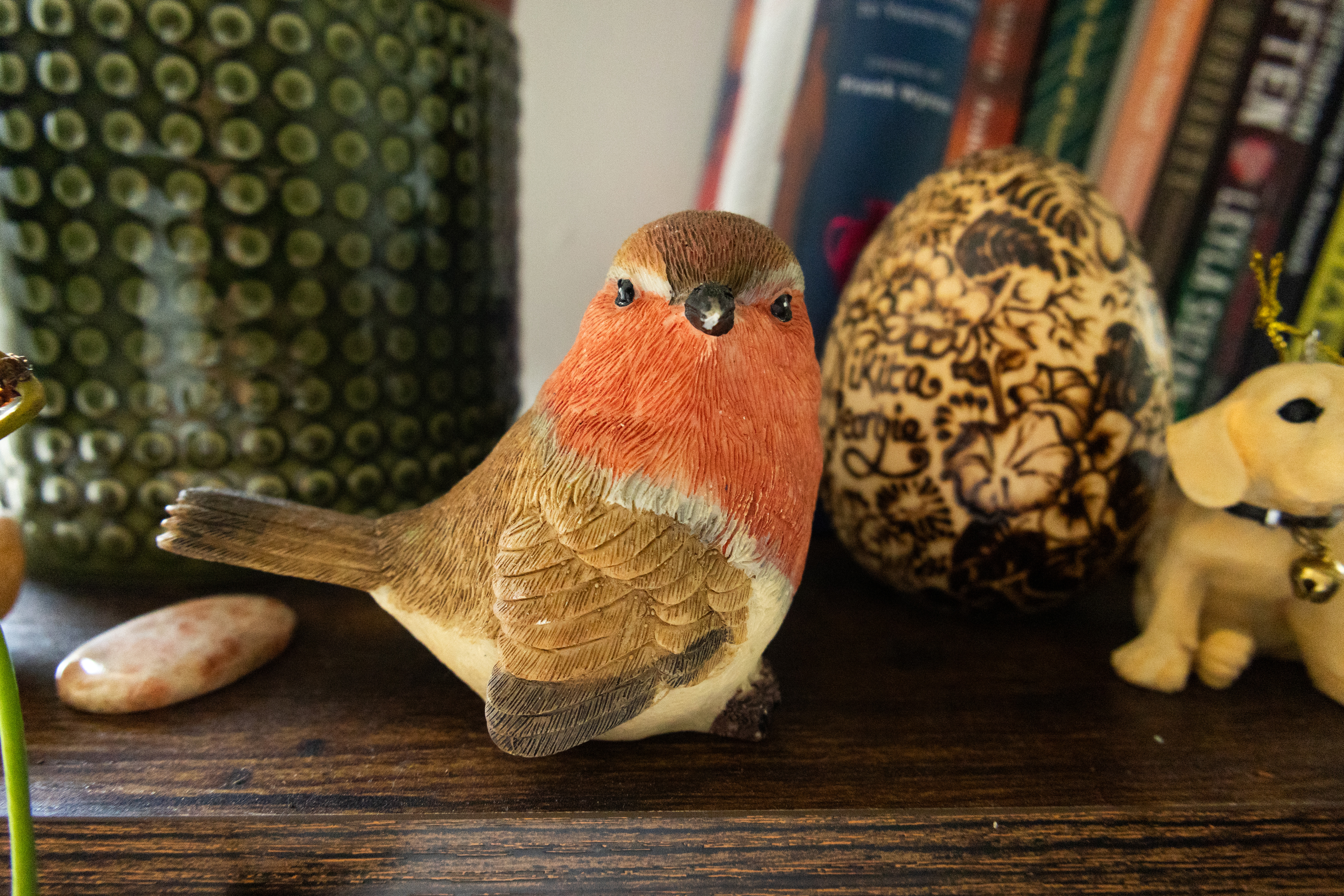 A photo of a robin figurine taken on a Canon EOS R50 V mirrorless video camera