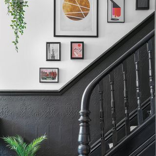 Gallery wall hanging above staircase painted black