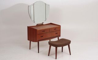 A brown wooden dressing table with mirror and stool