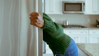 Is fasting good for you? Image shows person looking in fridge