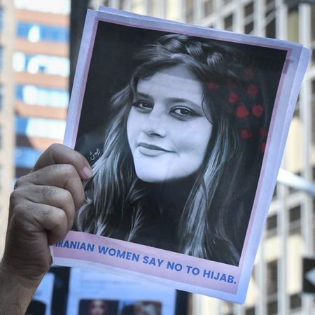 People hold up a photo of Iranian woman Mahsa Amini as they participate in a protest against Iranian President Ebrahim Raisi outside of the United Nations on September 21, 2022 in New York City. Protests have broke out over the death of 22-year-old Iranian woman Mahsa Amini, who died in police custody for allegedly violating the country's hijab rules. Amini's death has sparked protests across Iran and other countries. 