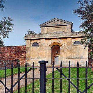 house exterior with green lawn black gate brick wall