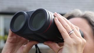 Image shows person using the Canon 10x42L IS WP binoculars.