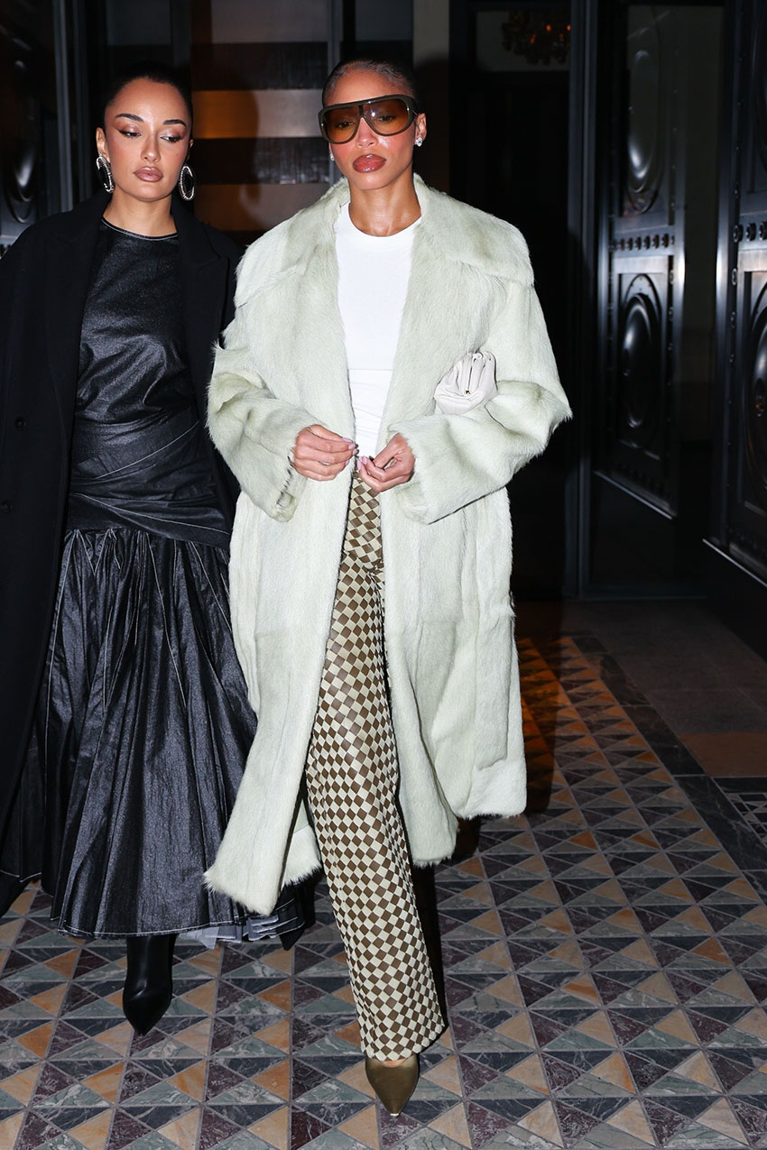 Lori Harvey wearing a coat, white t-shirt, plaid pants, and pointed toe heels