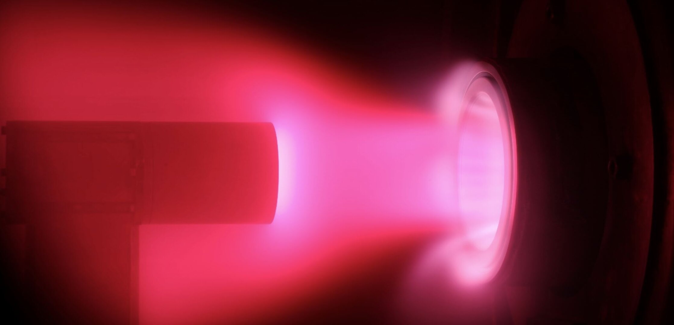 A pink glow seems to be coming out of a wind tunnel, encapsulating a piece of test equipment.