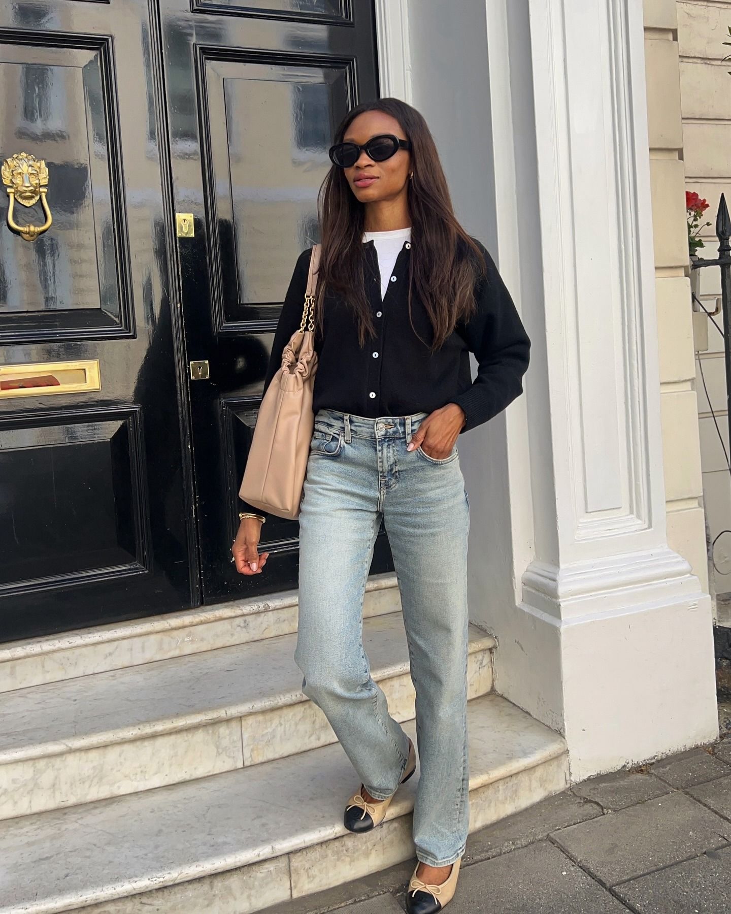 @lornasymphony wearing a white T-shirt and jeans outfit with a black cardigan, tote, and ballet flats