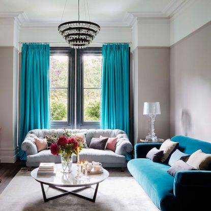 Blue and grey living room ideas with chandelier, grey and turquoise sofas and turquoise curtains