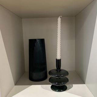 Spiral twist candle in black candle holder next to vase