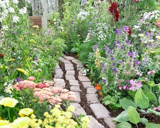 garden path made from reclaimed bricks leading through flowerbeds
