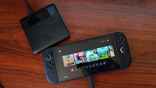 Baseus Blade power bank connected to Nintendo Switch 2 on woodgrain desk.