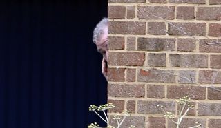 Jeremy Clarkson peers round a corner to let a car into his home (Steve Parsons/PA)
