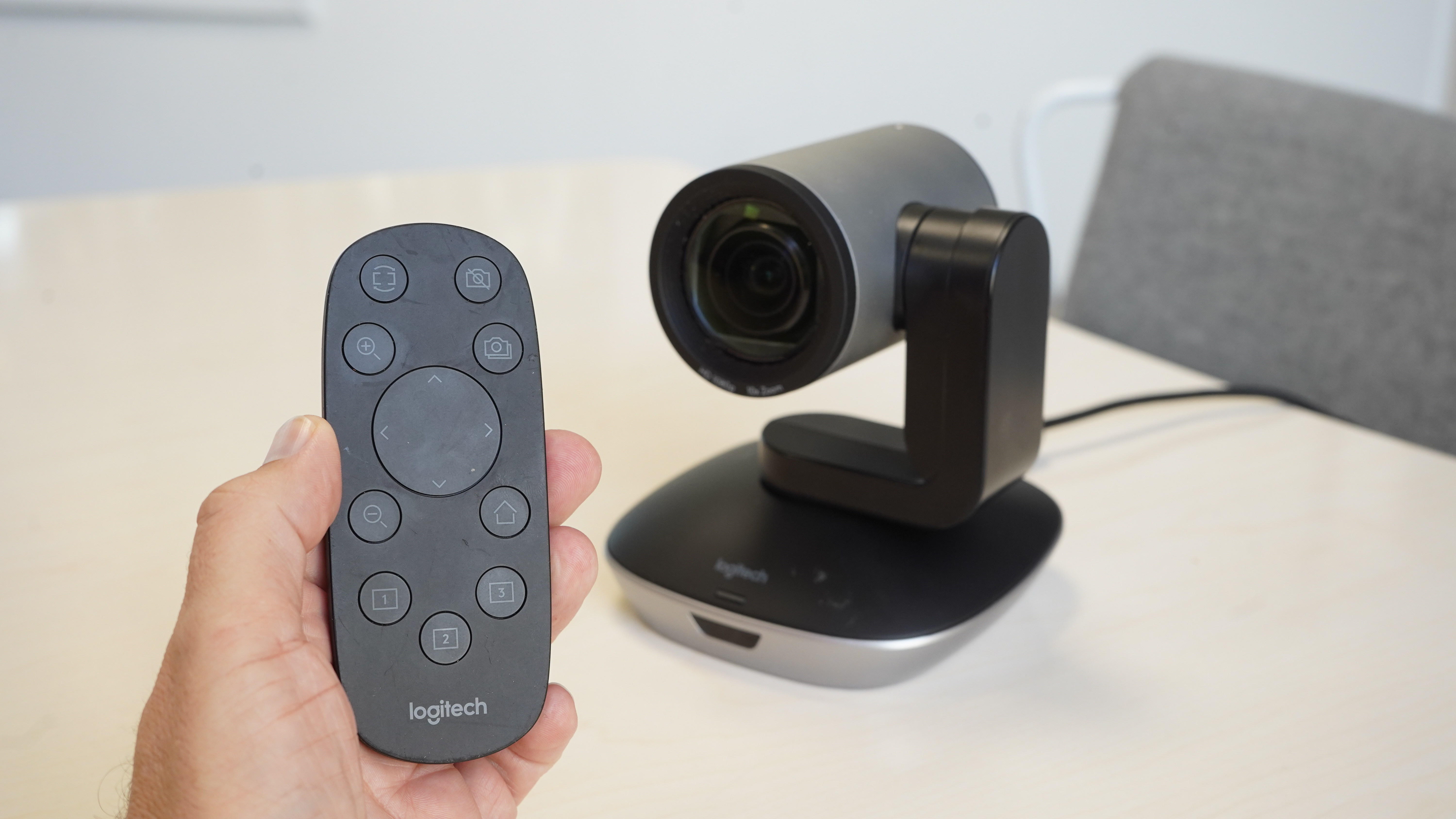 Logitech PTZ Pro 2 and remote control in hand