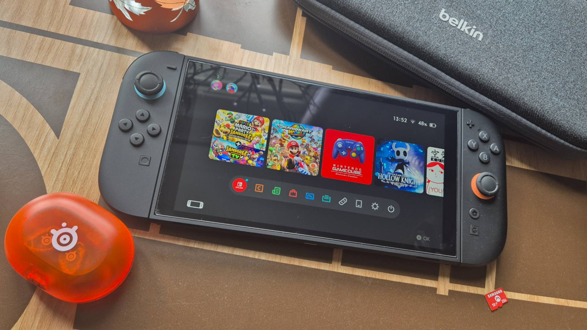 Photo by Rosalie Newcombe of the Switch 2 sitting on a wooden table with accessories sitting around it.