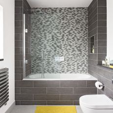 Bath and shower screen in grey and white bathroom