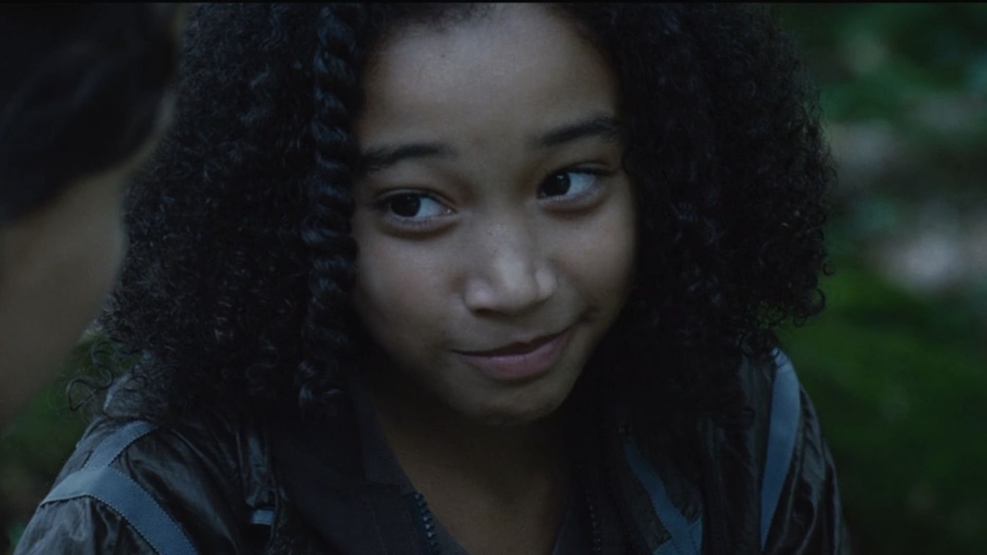 Rue smiling talking to Katniss about Peeta in The Hunger Games.