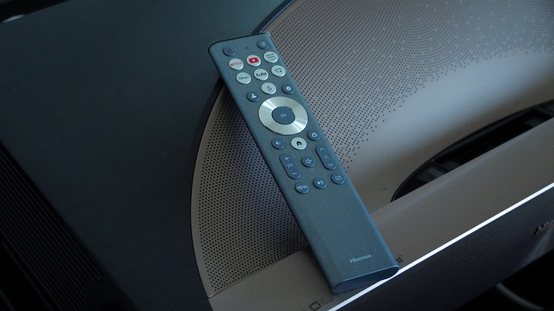 Hisense L9Q remote control on top surface of projector