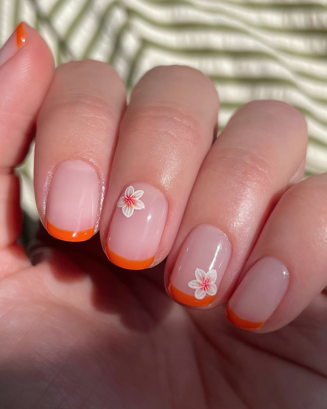 orange micro french manicure with floral designs