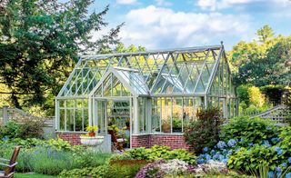 glass greenhouse and flowery garden