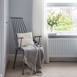 white linen bedroom curtains behind a grey chair