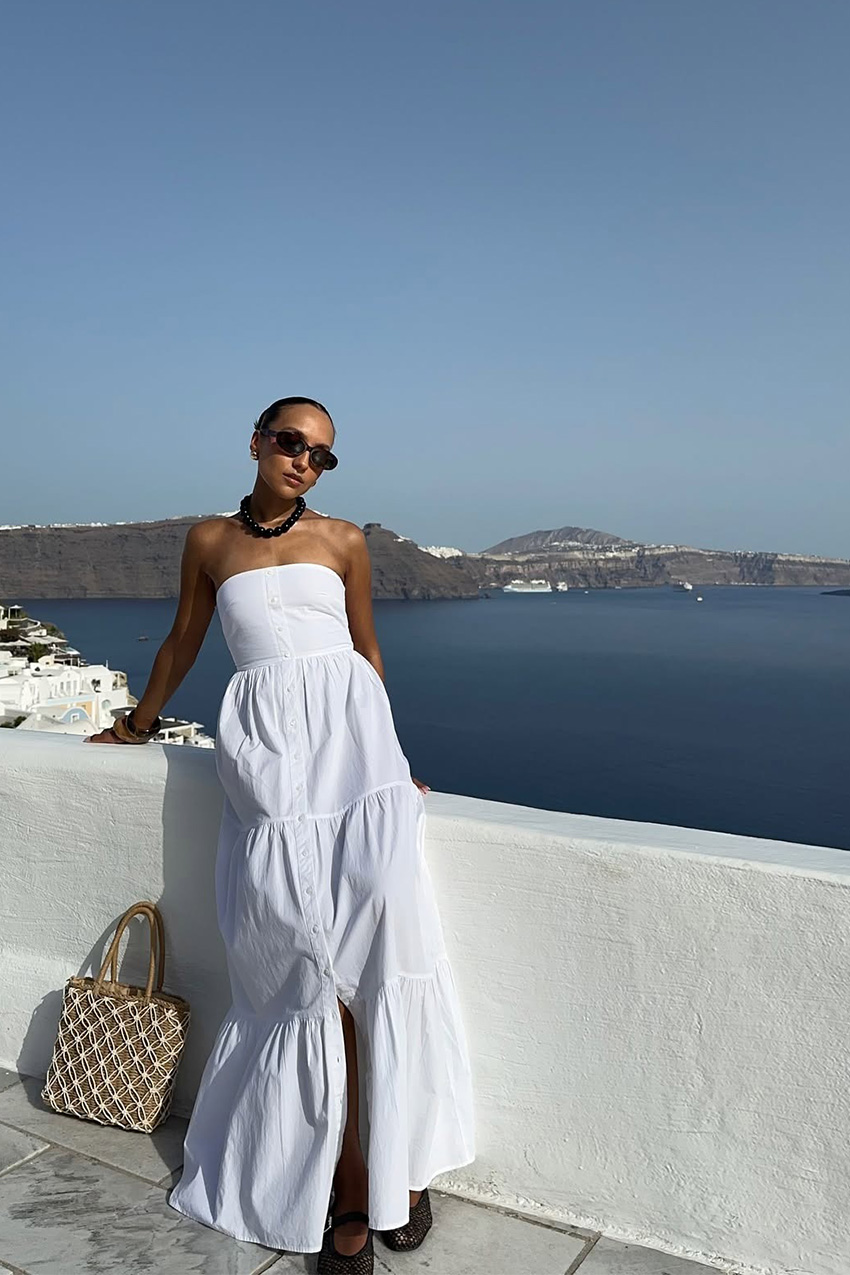 Woman wearing a white linen maxi dress.