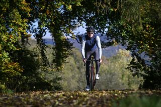 Male cyclist wearing a Castelli Espresso Vest riding on leafy country lane