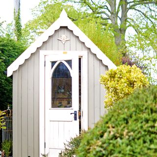 garden shed with white door and green trees