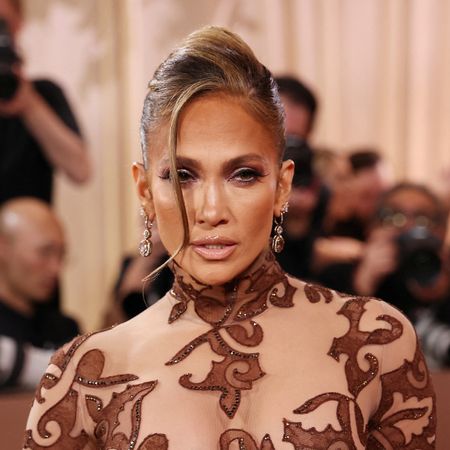 a woman wearing un updo while posing on a red carpet