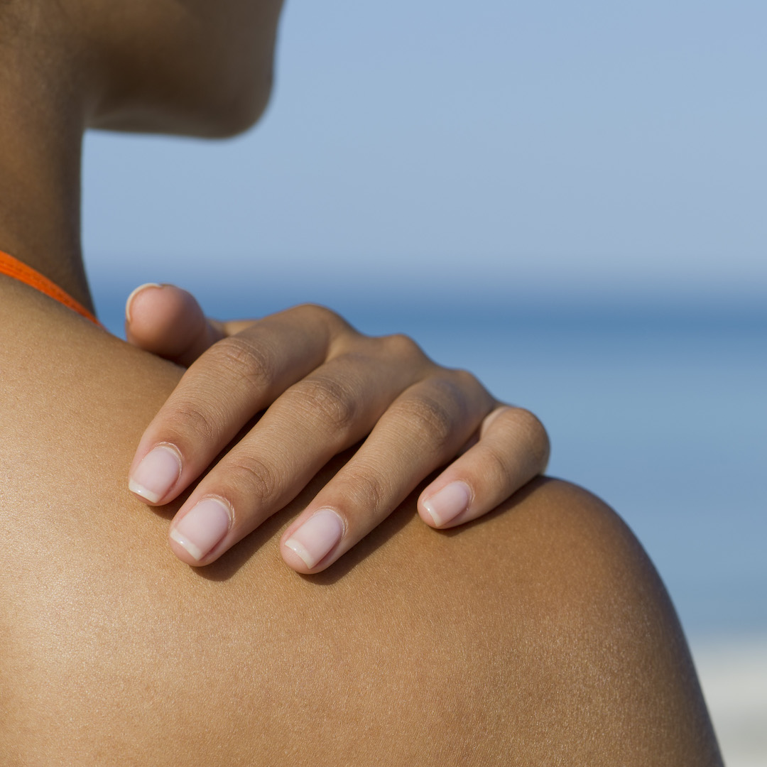 Woman touching bronzed shoulder