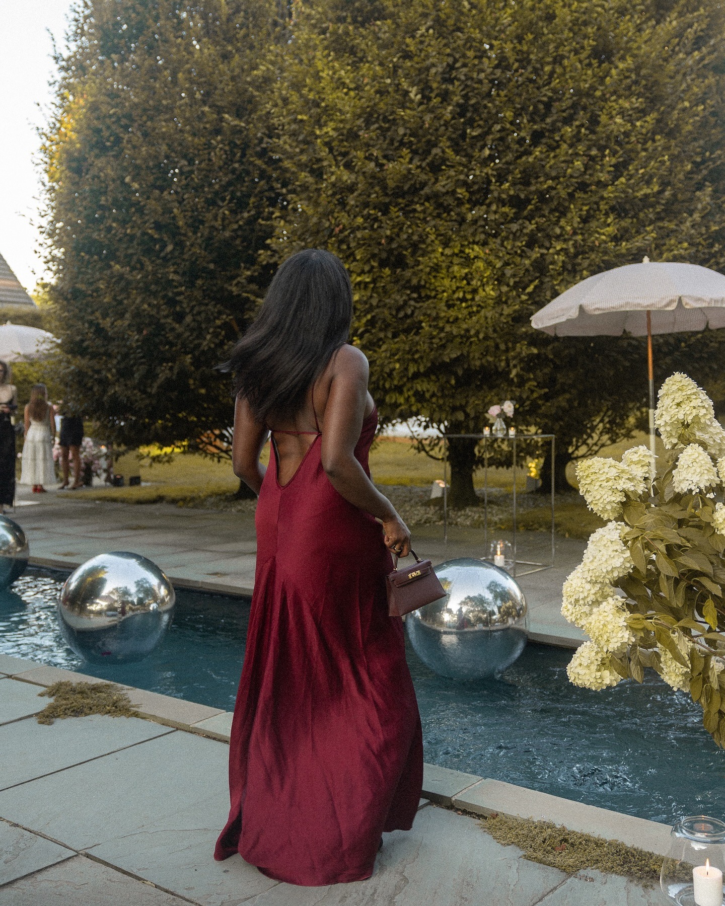 Criador @cocobassey tirando uma foto do lado de fora por uma piscina