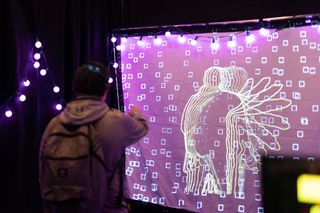 a college student interacts with a digital art installation.