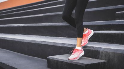 Woman in black leggings running down stairs