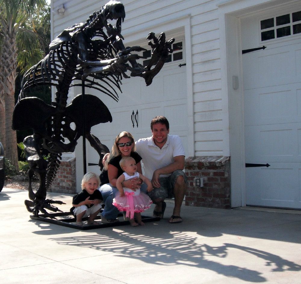 Commercial paleontologist Eric Prokopi of Gainesville, Florida with his wife, Amanda, and their two children in front of one of his earlier restoration projects, the skeleton of a giant ground sloth.