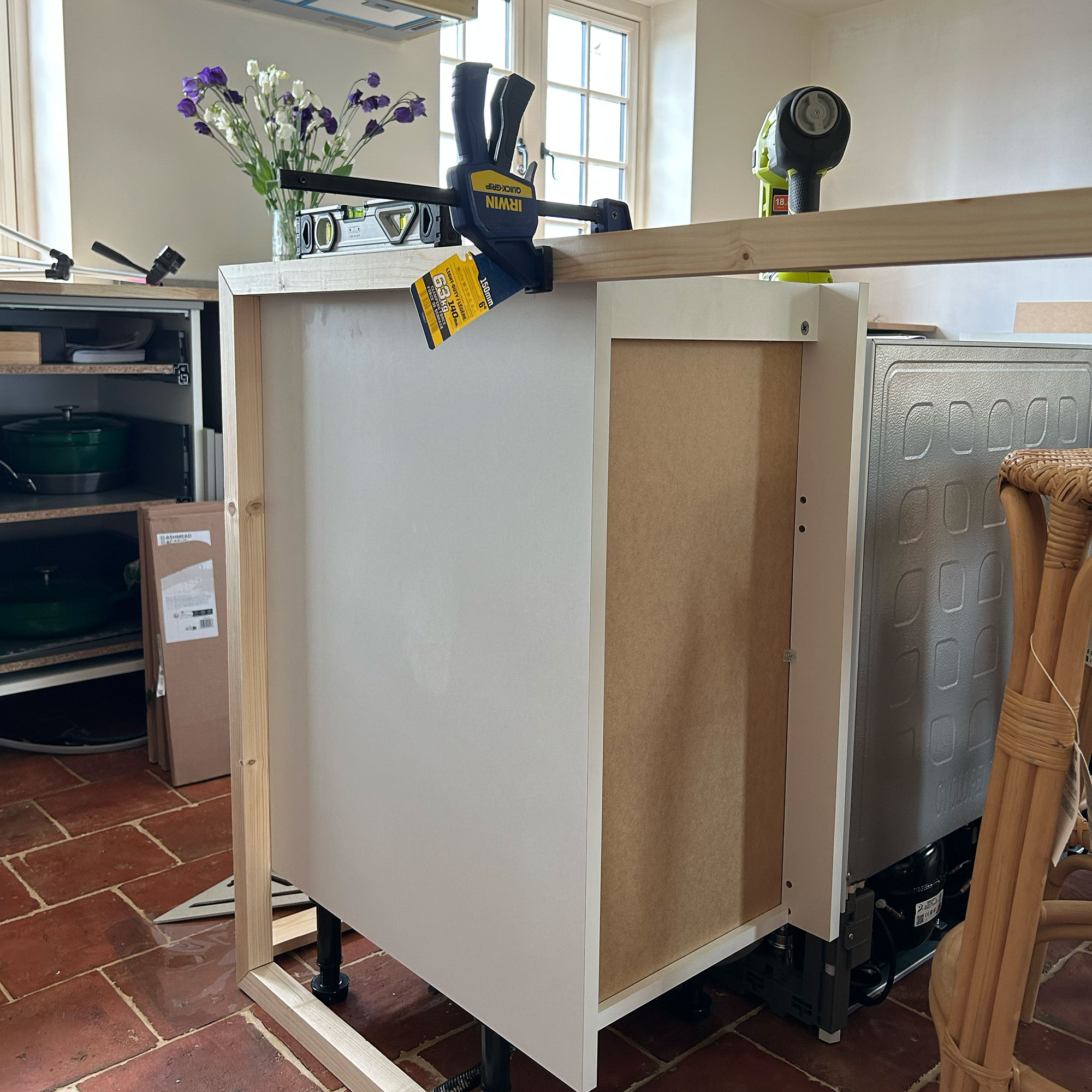 Structure of a kitchen island coming into shape, with wooden frame