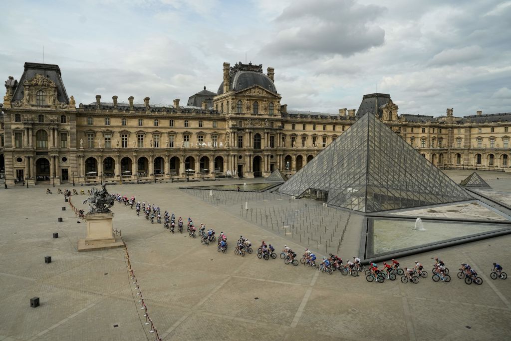The pack of riders races pass the Louvre Pyramid