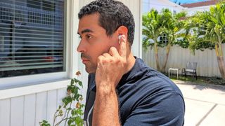 Tom's Guide reviewer testing controls on LG Tone Free T90 earbuds