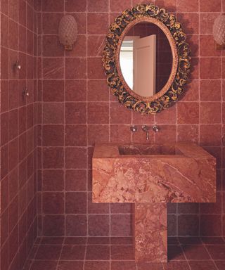 bathroom with orange tiles and marble sink and mirror on wall