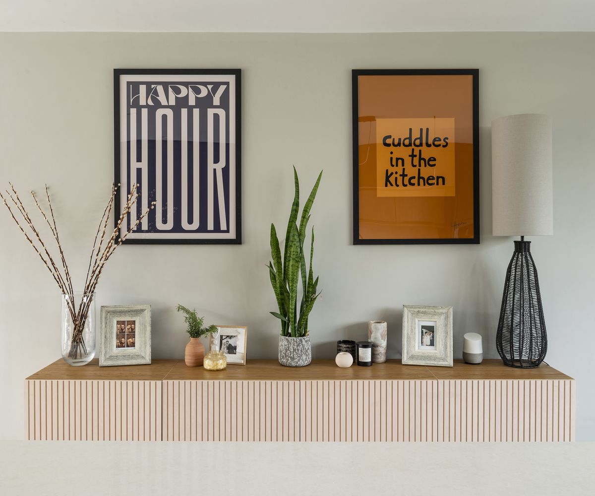 A floating shelf adorned with personal trinkets all in a Scandi style. There are two pieces of wall art posters with a cutesy vibe