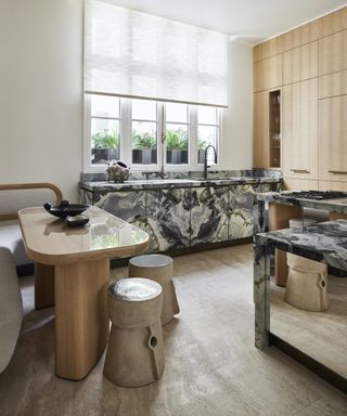 marble clad kitchen with mirrored island and travertine flooring