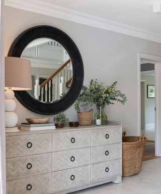 landing with round mirror and chest of drawers