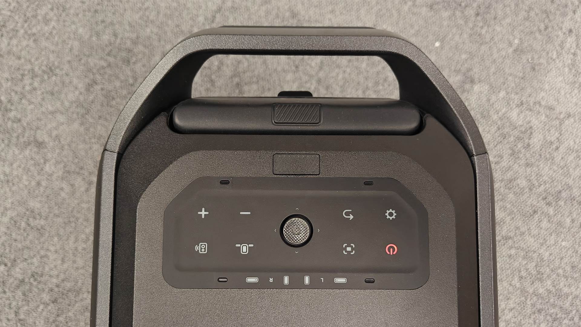 Soundcore Nebula X1 Pro home cinema projector on grey carpet, top of unit controls