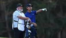 Min Woo Lee and his caddie chat during The Players Championship