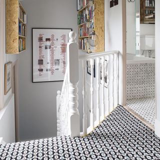 hallway with patterned carpet and bookshelves on wall