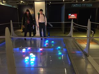 MoMath co-founders Glen Whitney and Cindy Lawrence play around inside the museum's new "Robot Swarm" exhibit.