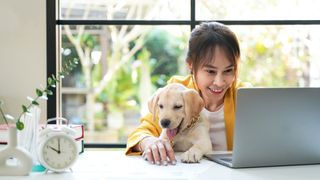 Woman on laptop with puppy