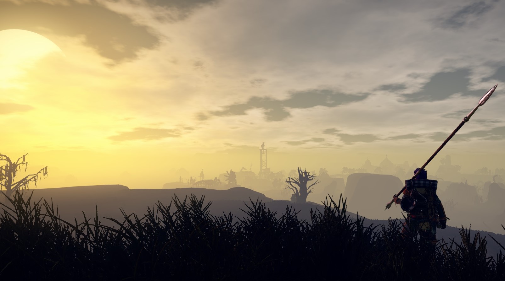 Outward - A player stands on a grassy hill looking at the sunrise over distant hills.