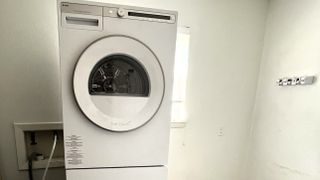 Whole ASKO Tumble Dryer T411VDW machine on top of washer