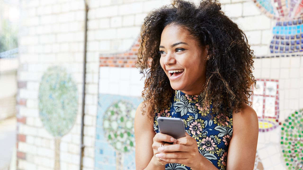 woman smiling on phone with mosaic tile background