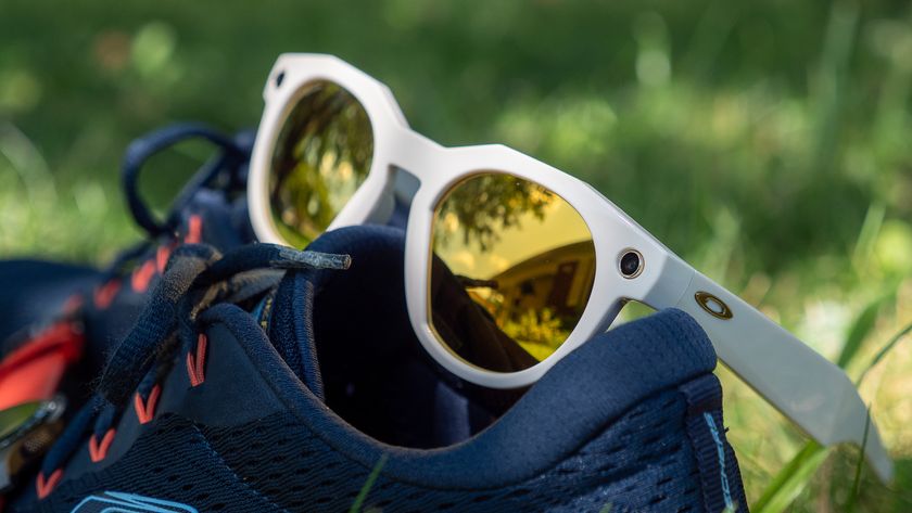 A pair of warm white limited edition Oakley Meta HSTN smart glasses with PRIZM lenses with running shoes