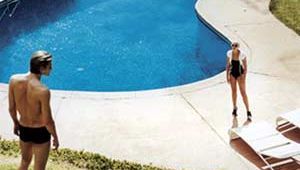 Man and woman standing by swimming pool